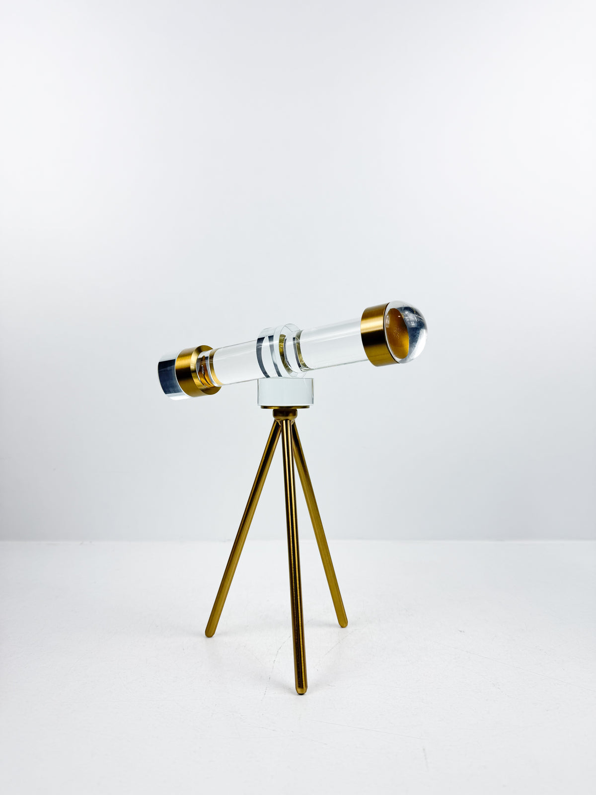 Télescope décoratif en cristal sur trépied en métal doré.