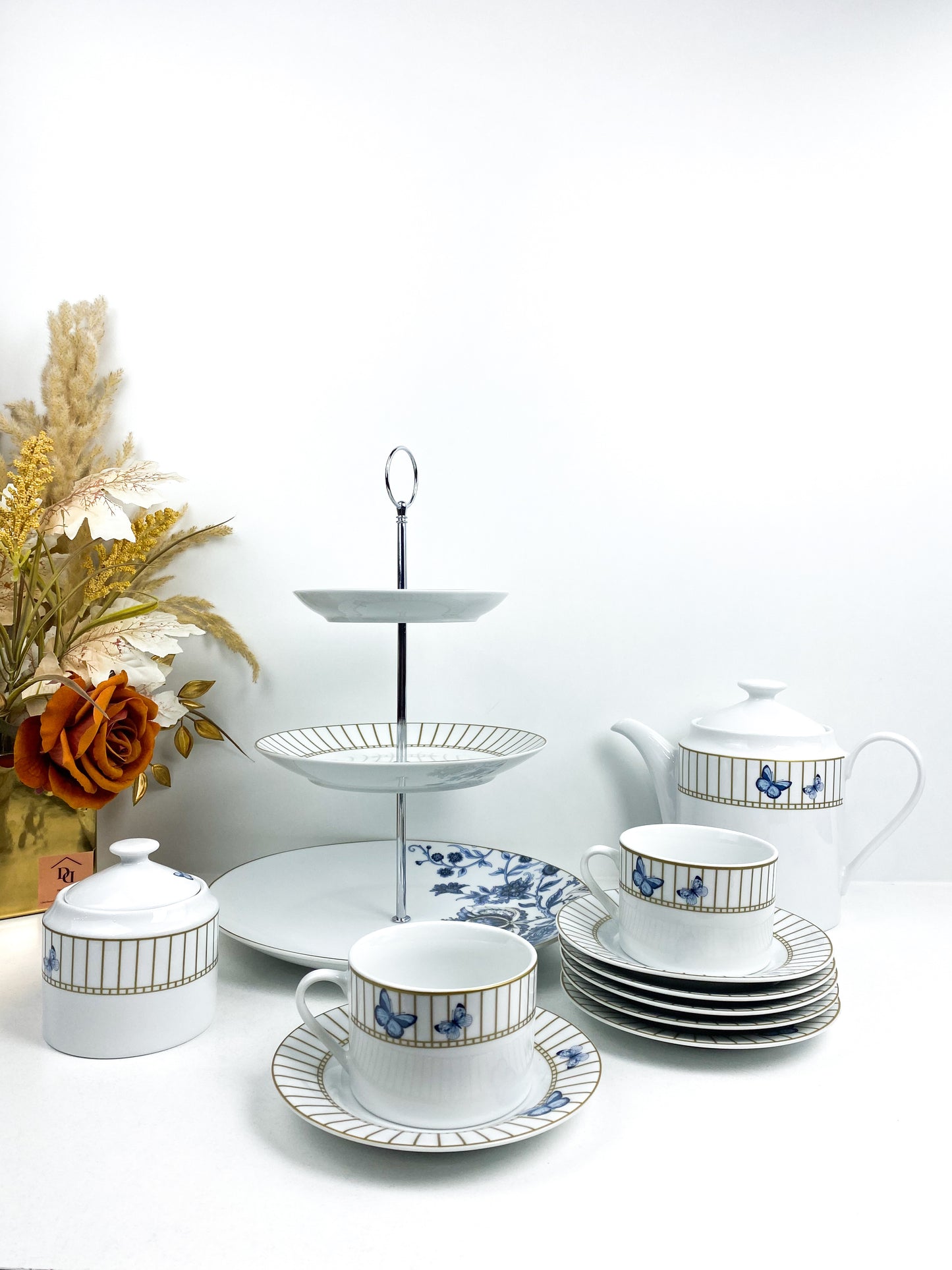 Service à thé en porcelaine décoré de motifs de papillons et d'une cage à oiseaux