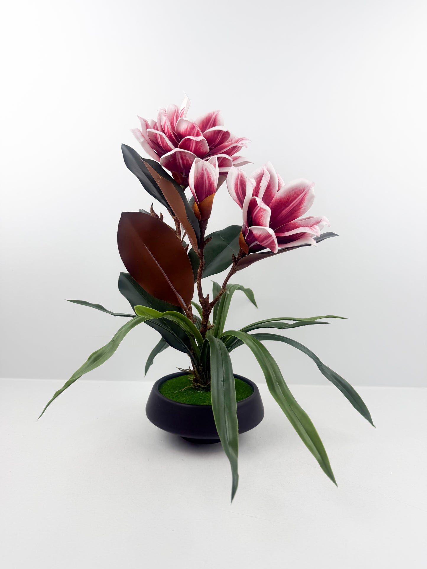 Fleurs artificielles haut de gamme associées à un élégant pot en céramique noir