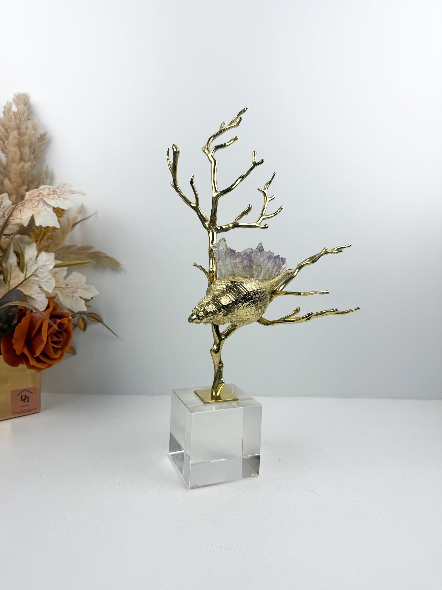 Sculpture de luxe de forme coquillage alliant l'élégance intemporelle du laiton doré aux reflets captivants des cristaux naturels.