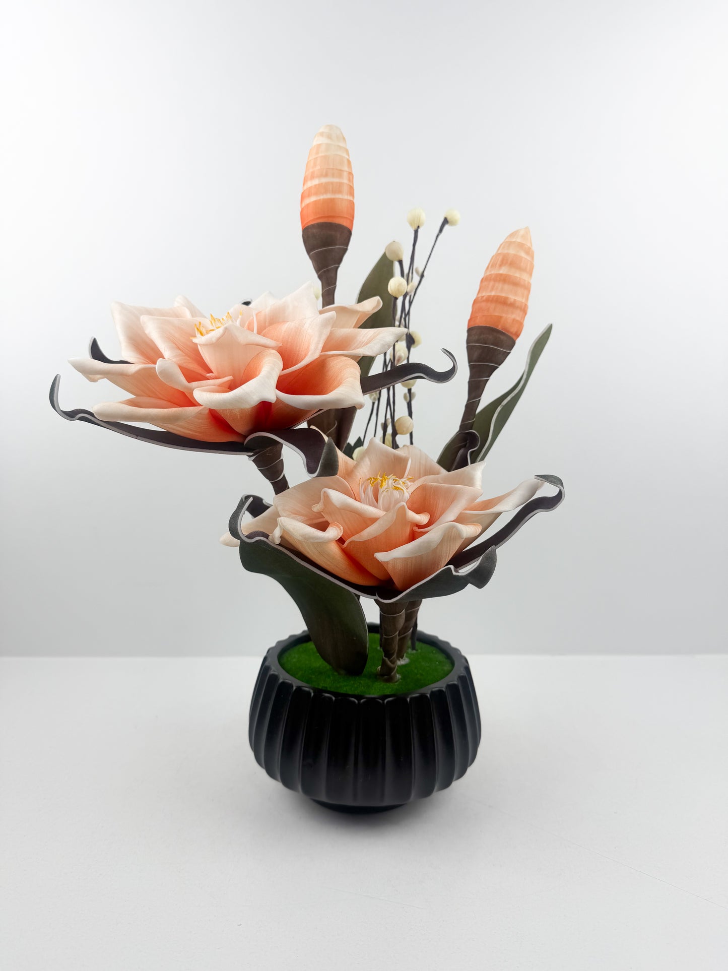 Fleurs oranges artificielles de qualité dans un pot noir haut de gamme