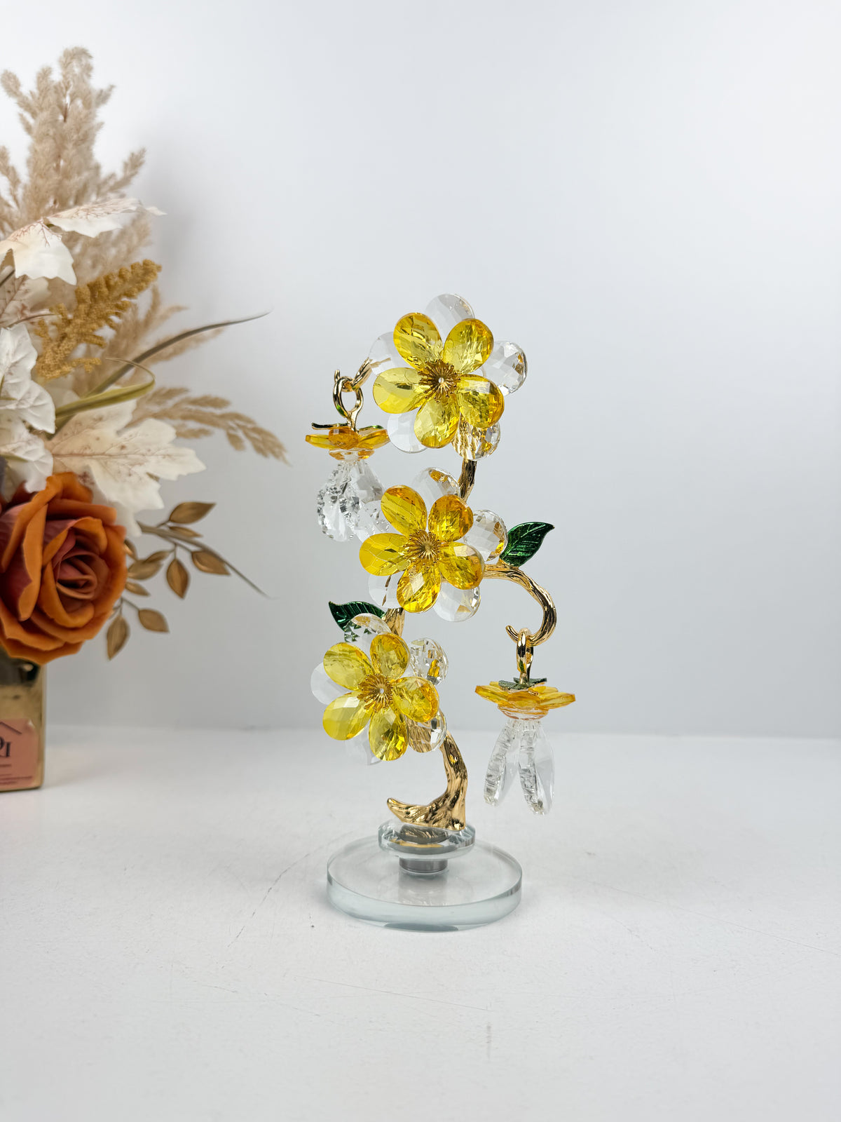 Sculpture d'arbre décoratif avec fleurs et cristaux dorés.