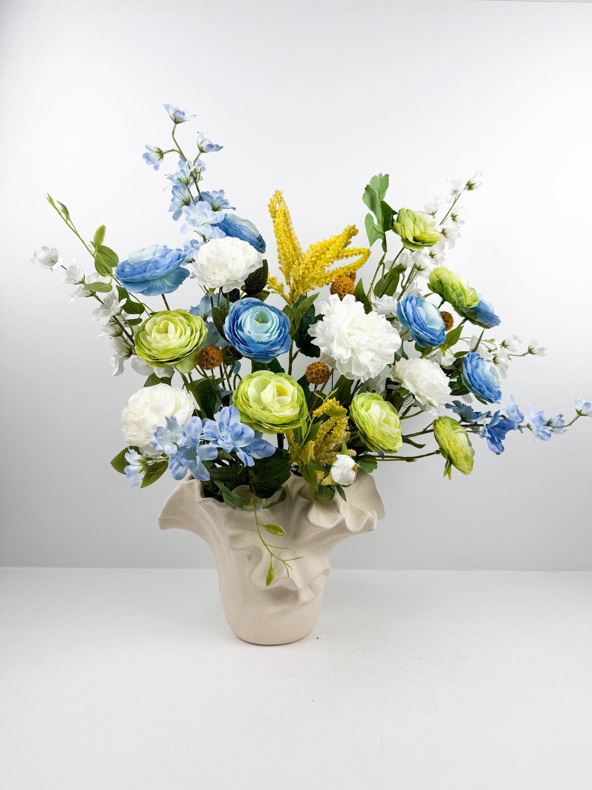 Fleurs artificielles dans un vase en céramique texturée au design original.