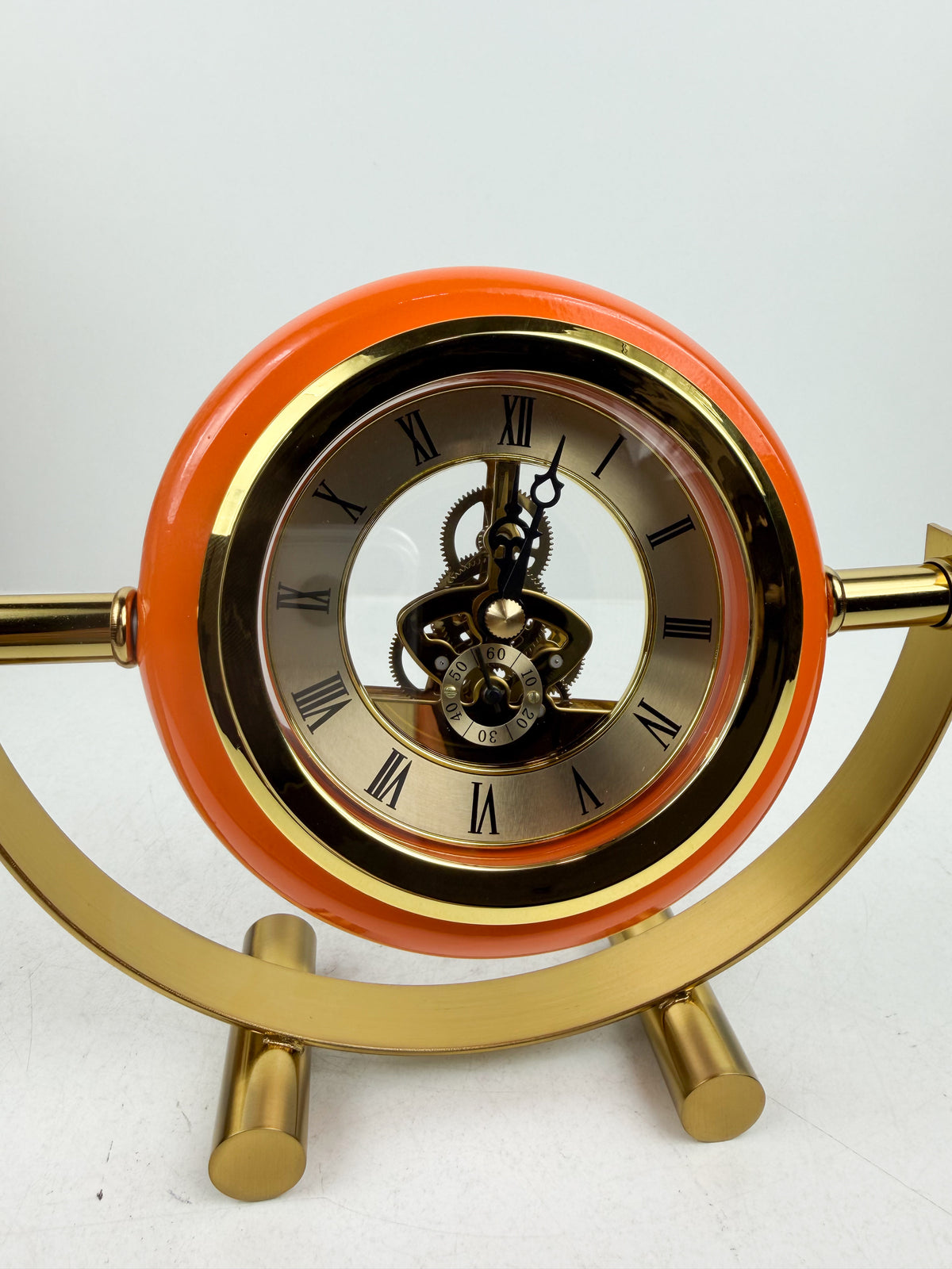 Horloge de table en métal doré de contour orange.