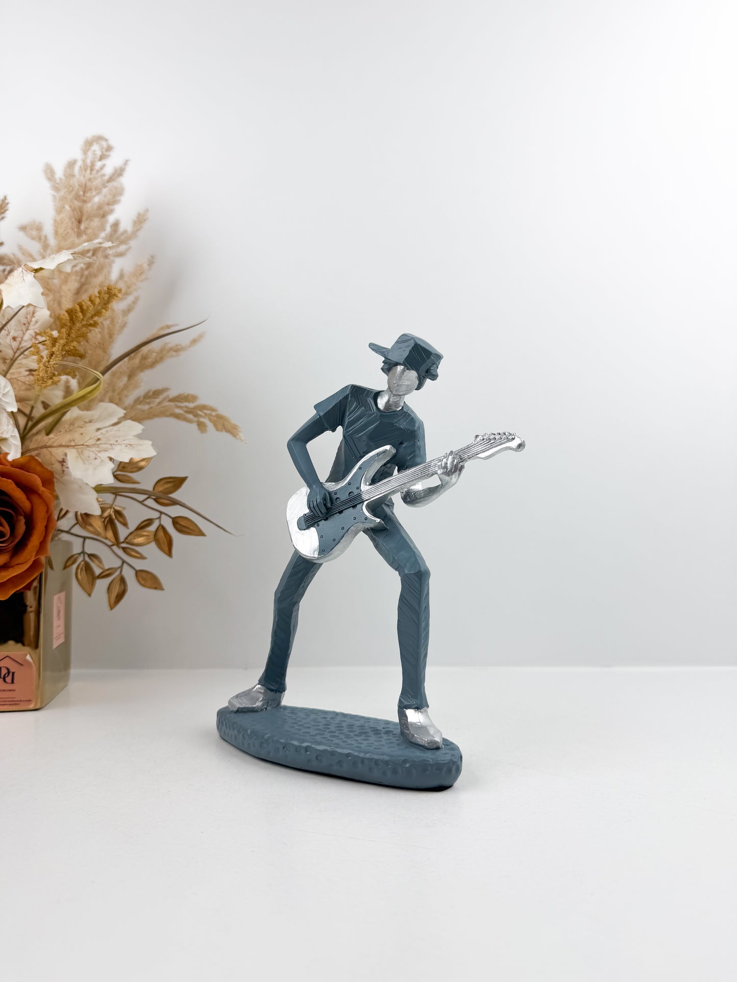 Figurine décorative représentant un guitariste élégant.
