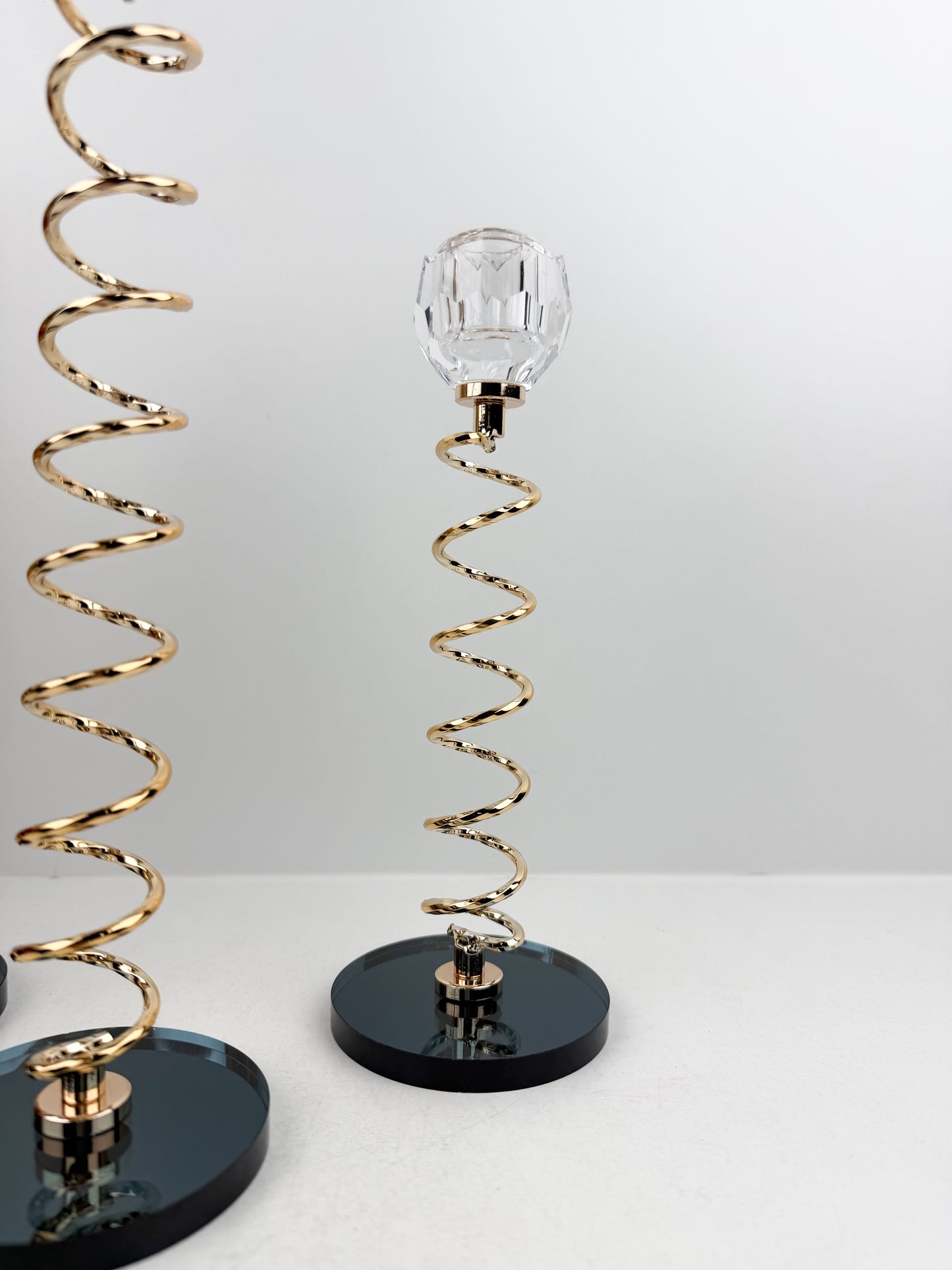 Trio de Bougeoirs en cristal doré sur un socle noir.