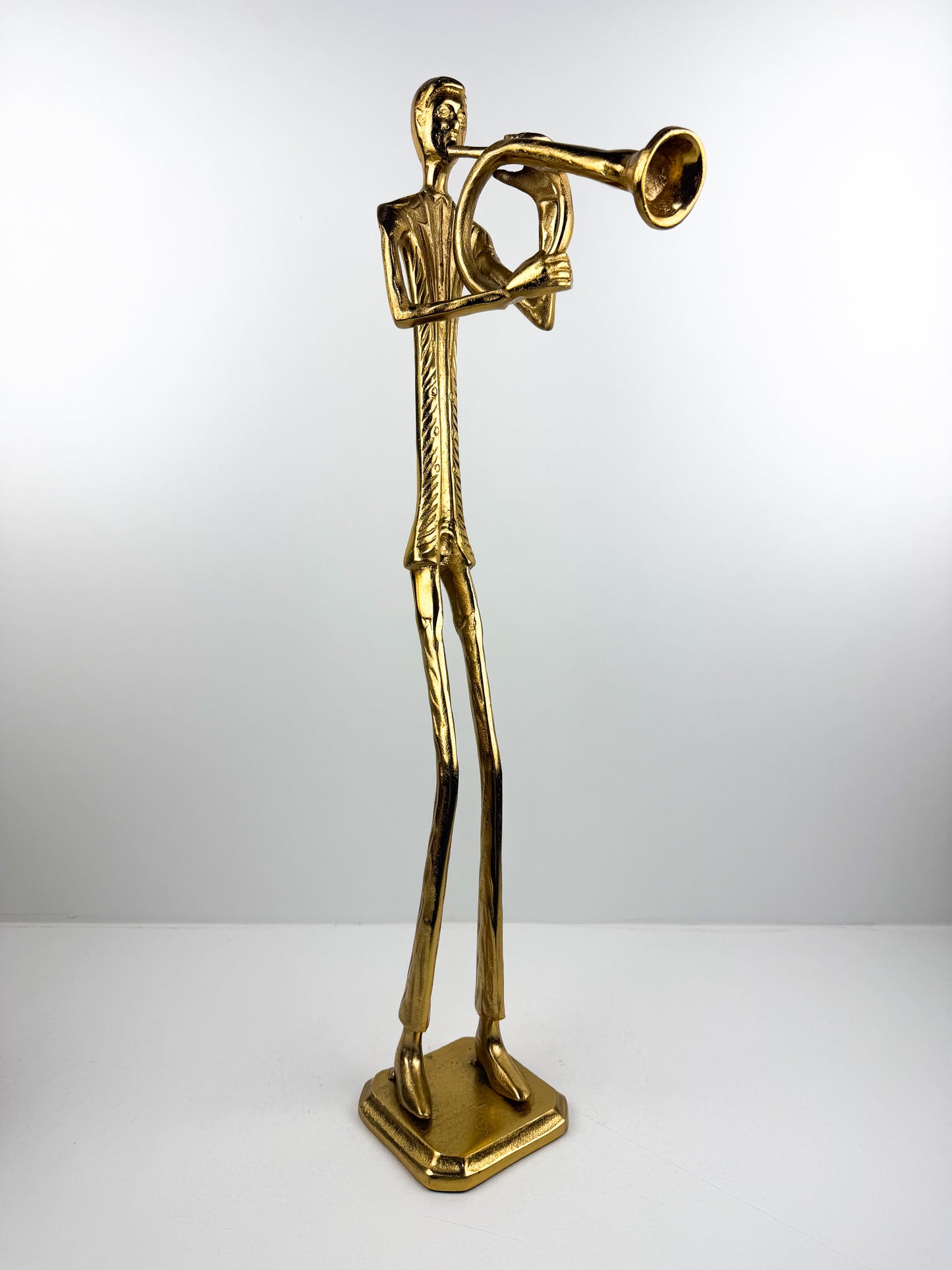Figurine élégante d'un musicien jouant de la trompette en métal