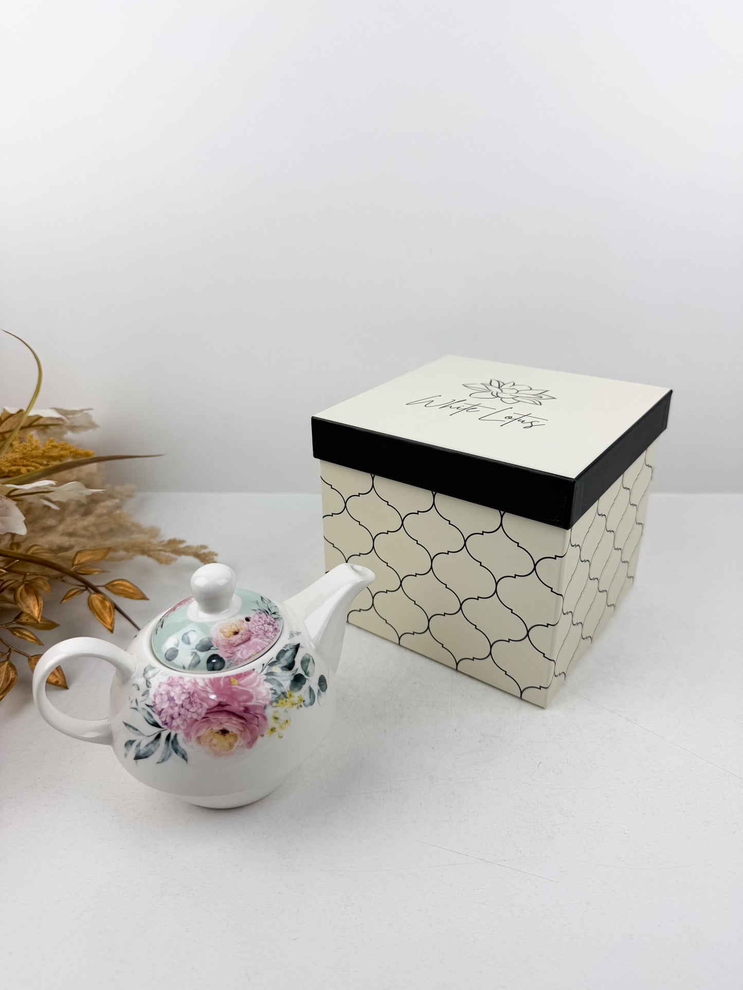 Théière élégante d'une tasse accompagnée de sous-tasse raffinée de motif floral