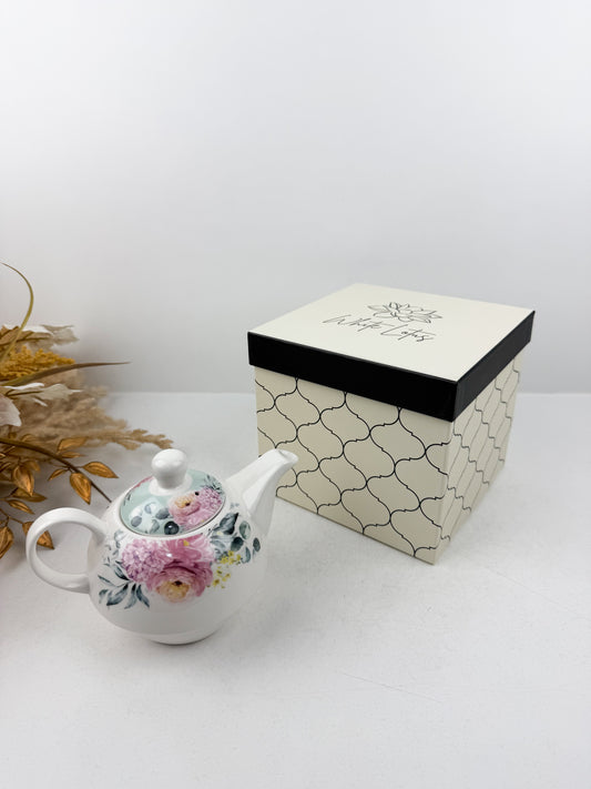 Théière élégante d'une tasse accompagnée de sous-tasse raffinée de motif floral