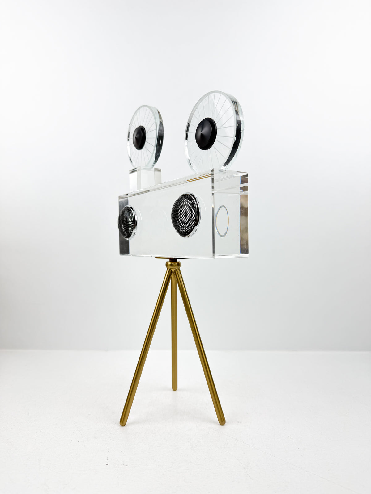 Projecteur caméra cinéma vintage sur trépied doré.