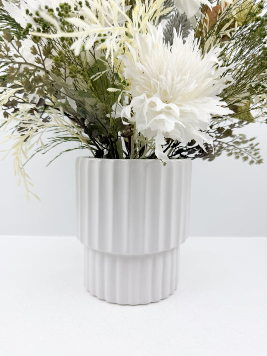 Fleurs artificielles d'une élégance intemporelle dans un vase blanc aux lignes épurées