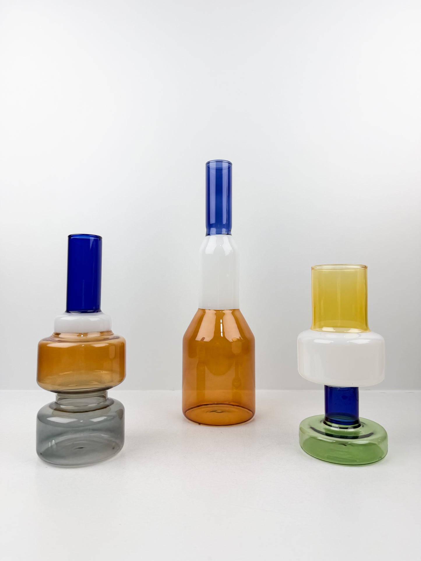 Trio de vases géométriques aux formes épurées et aux couleurs variées.