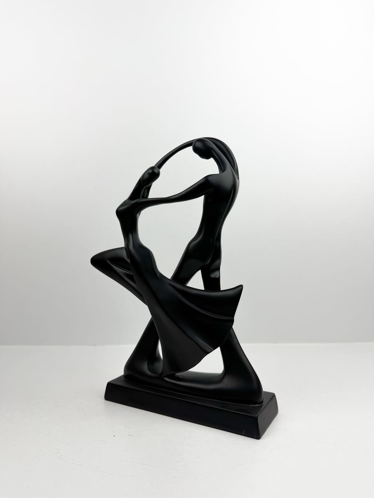 Duo de sculpture décorative entrelacées dans une posture de danse fluide et élégante.