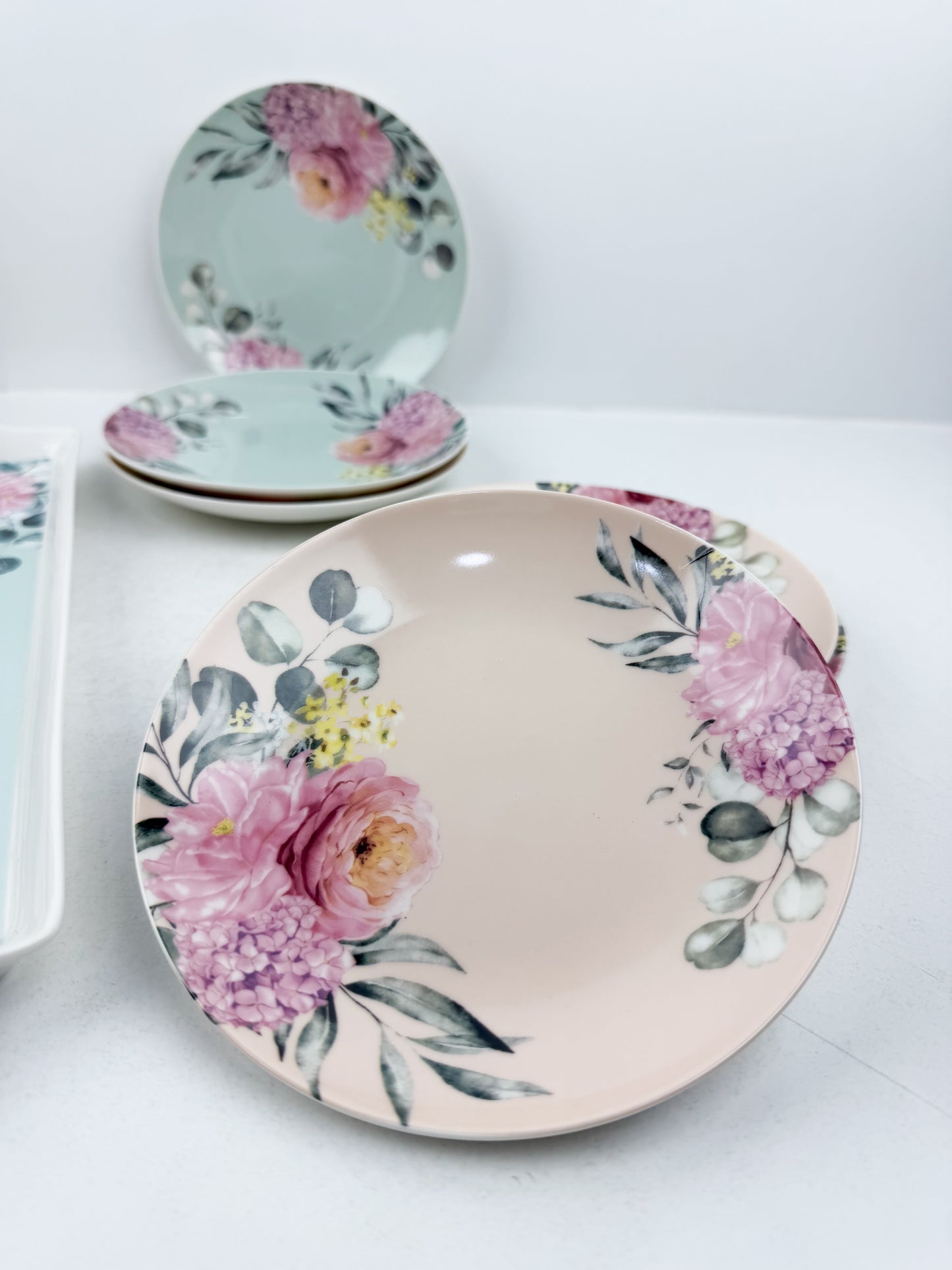 Grande assiette de service accompagnée de six assiettes assorties aux motifs floraux