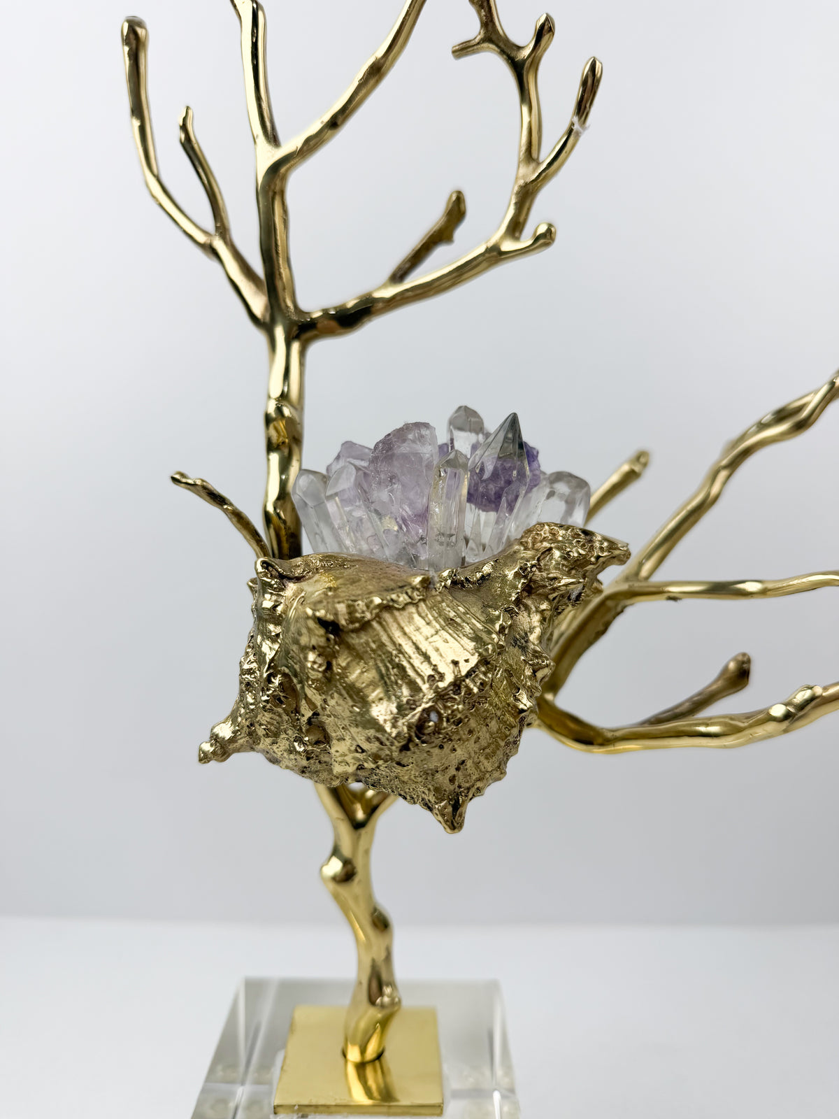 Sculpture de luxe de forme coquillage alliant l'élégance intemporelle du laiton doré aux reflets captivants des cristaux naturels.