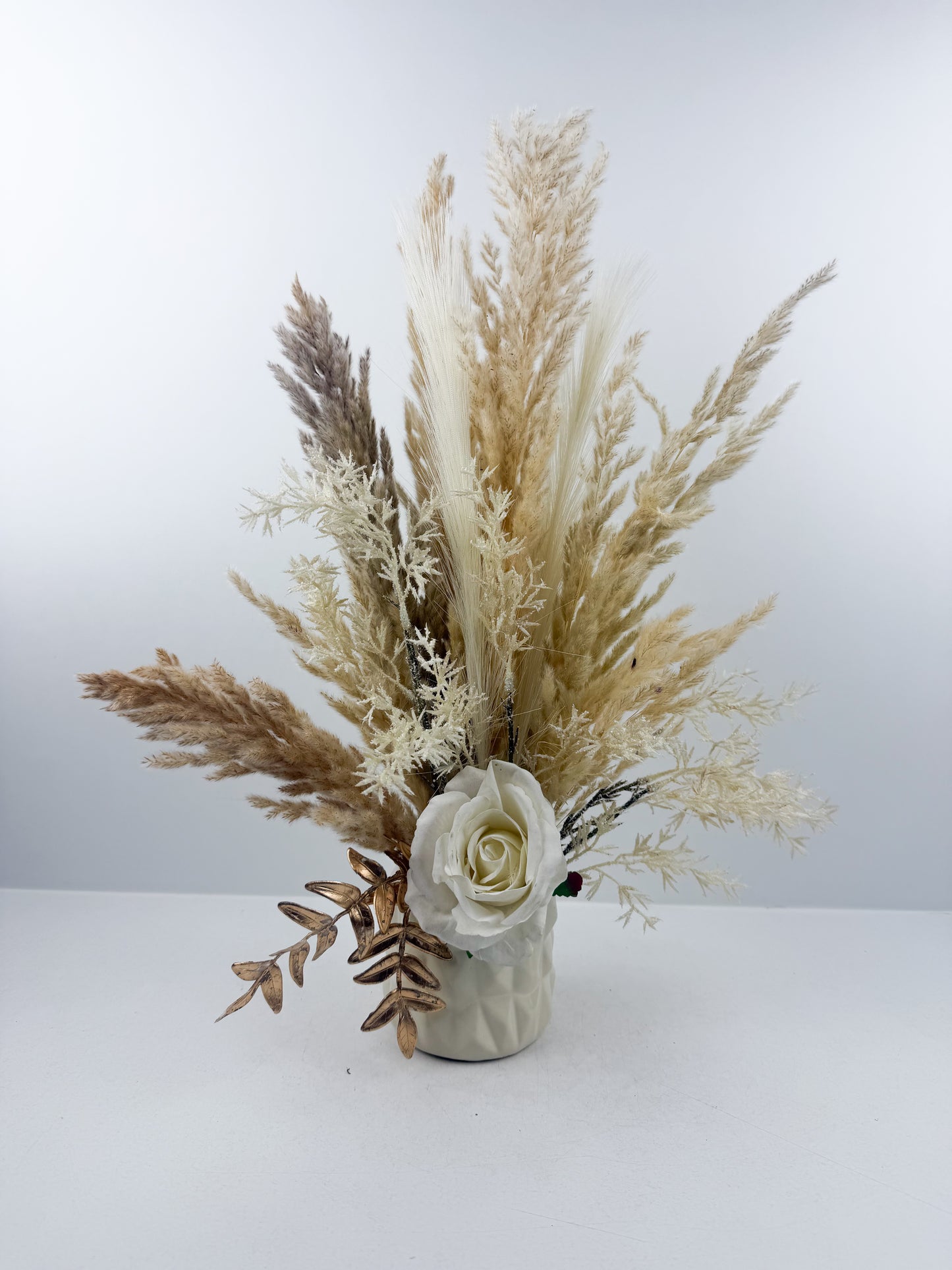 Fleurs séchées aux teintes beige naturels, sublimé par une fleur blanche délicate qui apporte une touche d'élégance intemporelle.&nbsp;