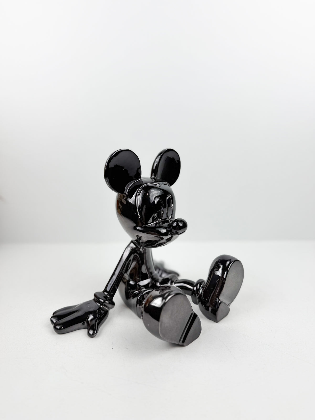 Statuette décorative en résine de Mickey Mouse en position assise.