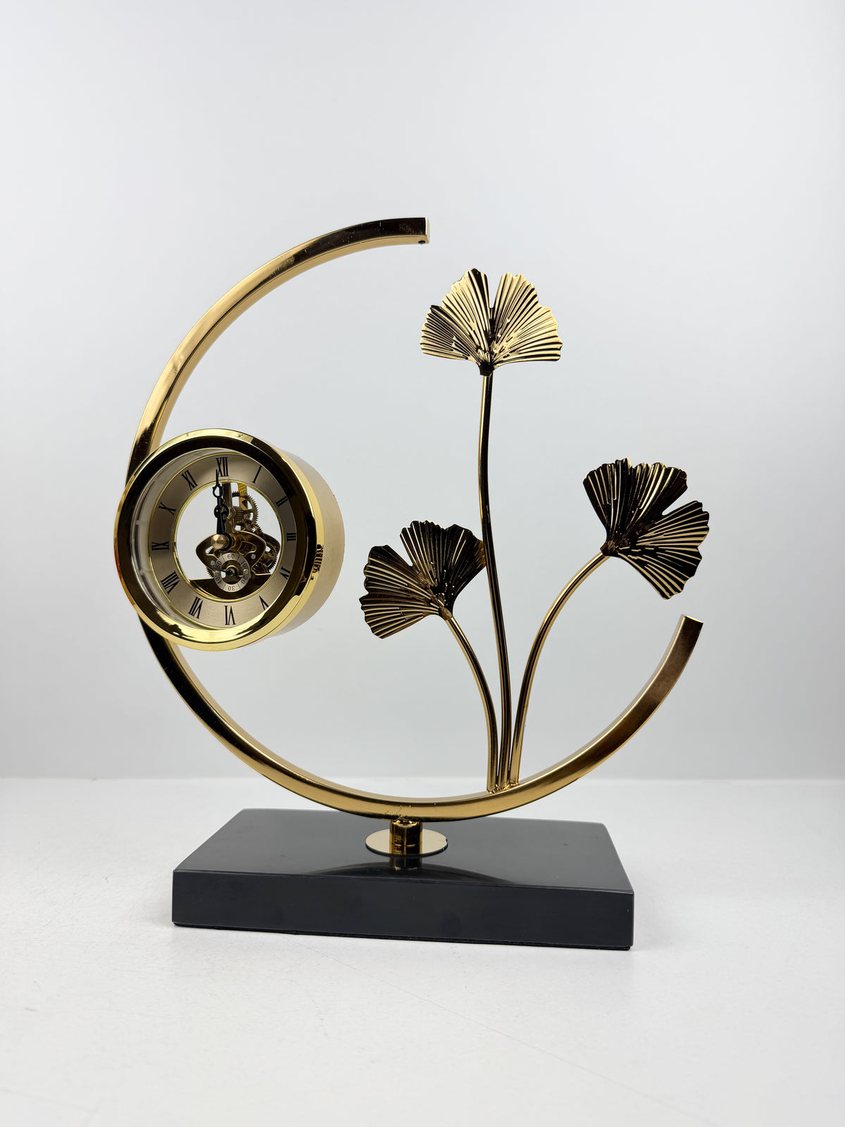 Horloge de table sculpturale en métal doré.