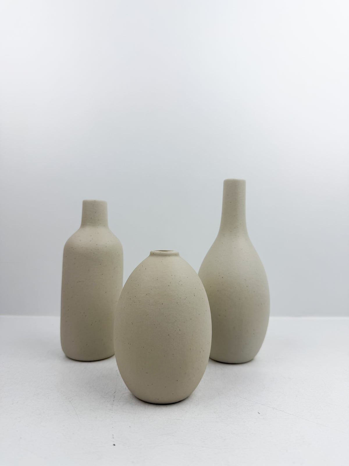 Ensemble de trois vases miniatures en céramique blanc pur.
