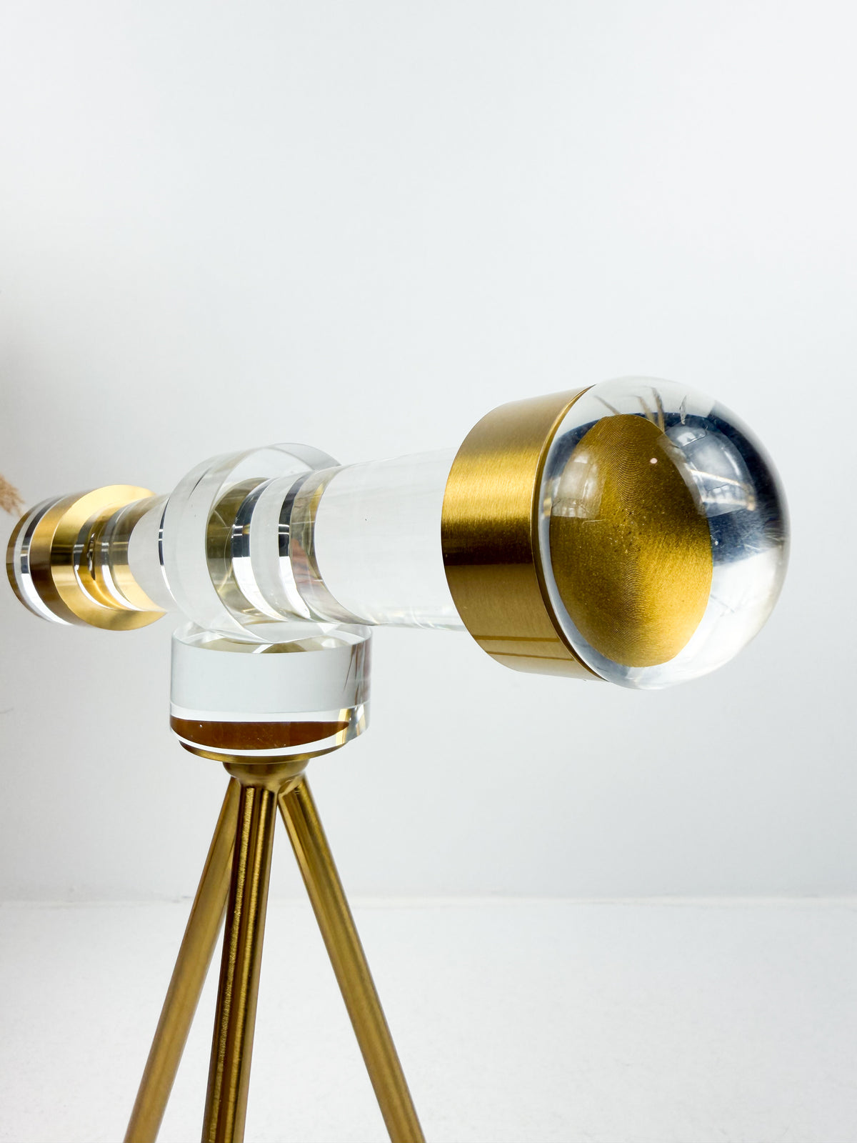 Télescope décoratif en cristal sur trépied en métal doré.