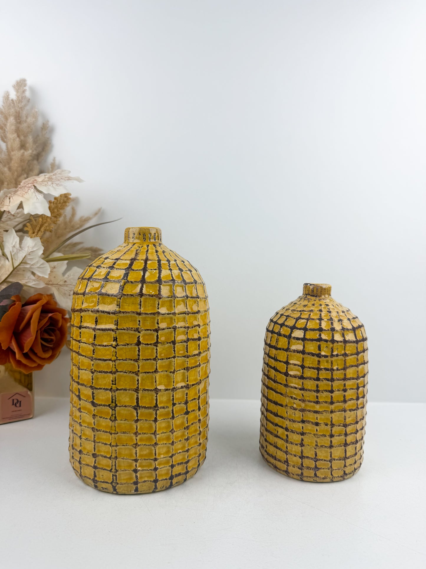 Duo de vases artisanal en céramique motif quadrillé jaune et noir.