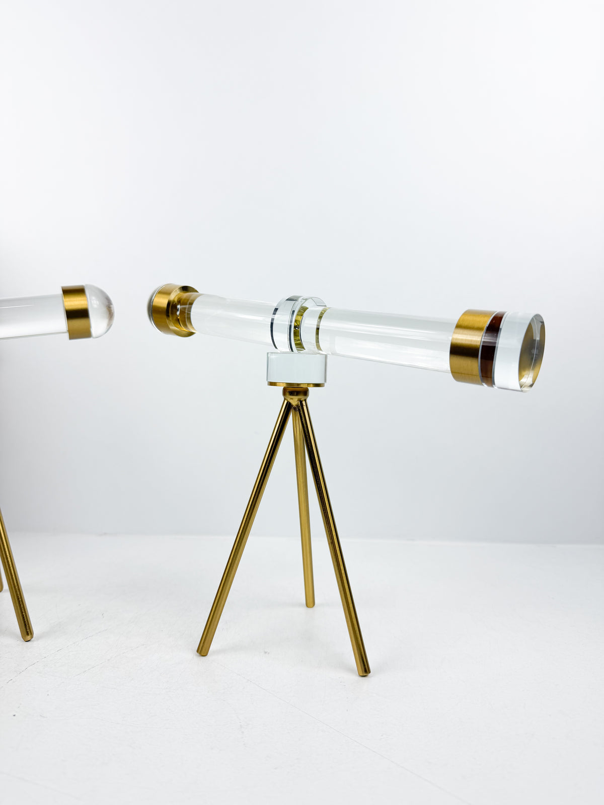 Télescope décoratif en cristal sur trépied en métal doré.