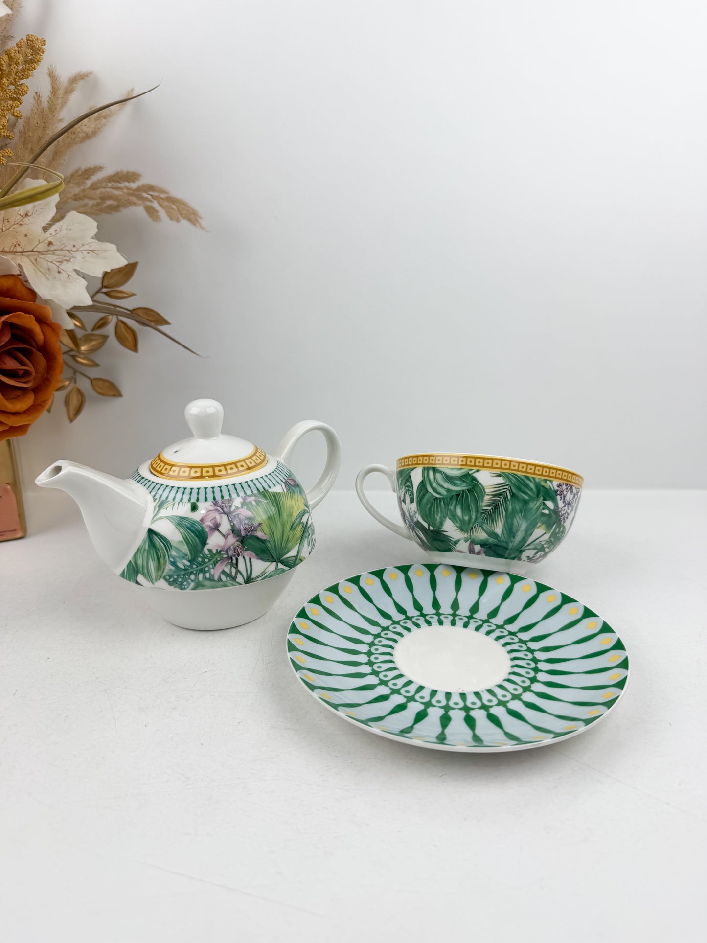 Théière élégante d'une tasse accompagnée de sous-tasse raffinée de motif jungle