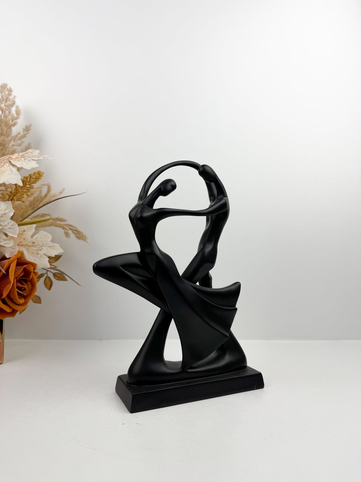 Duo de sculpture décorative entrelacées dans une posture de danse fluide et élégante.