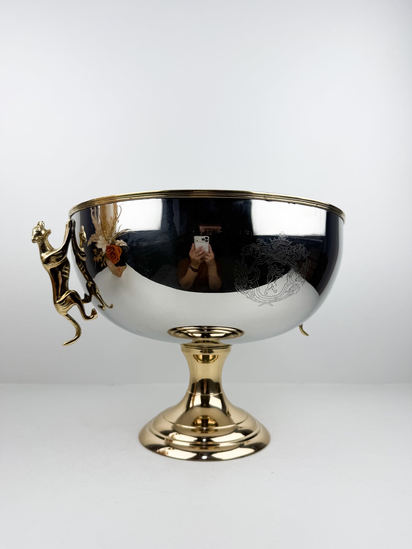 Présentoir très chic et luxe en métal miroir avec pieds dorés et poignées en forme de tigre.
