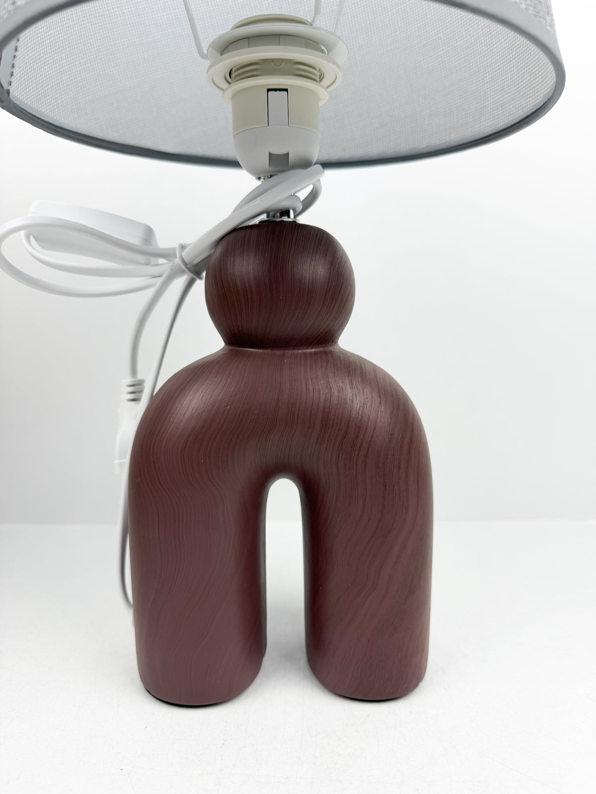 Lampe à Poser Sculpturale de pied en céramique mat d'un abat-Jour gris texturé.