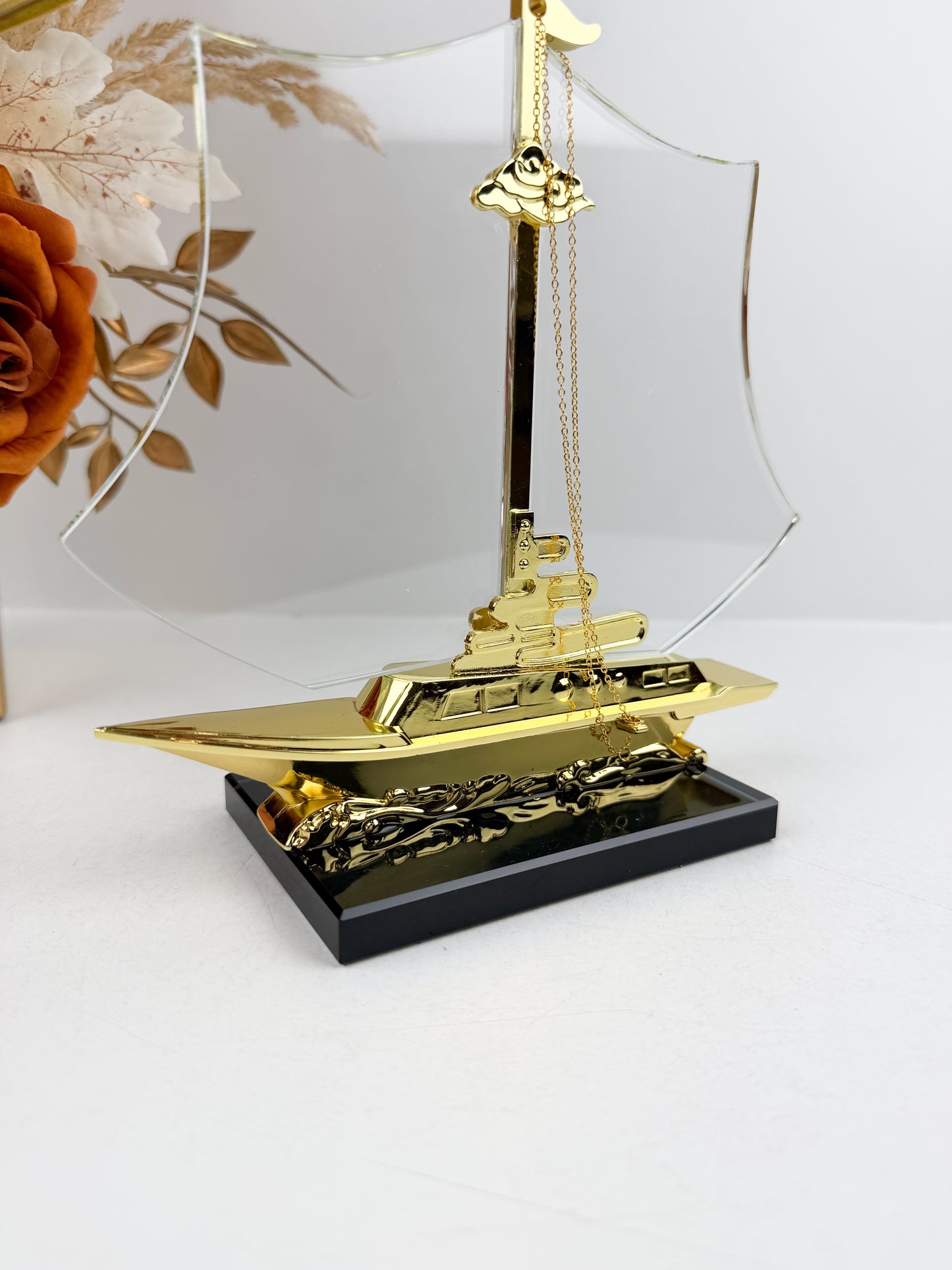 Bateau décoratif doré reposant sur un élégant socle noir
