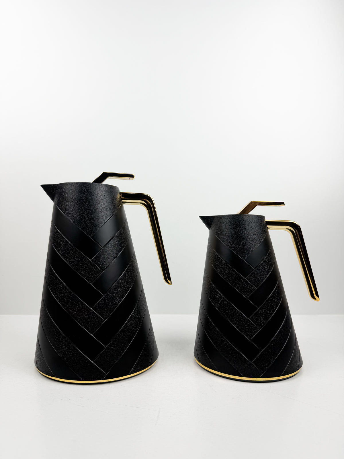 Duo de thermos isothermes noirs mats avec motifs chevrons en relief, anses et détails dorés.
