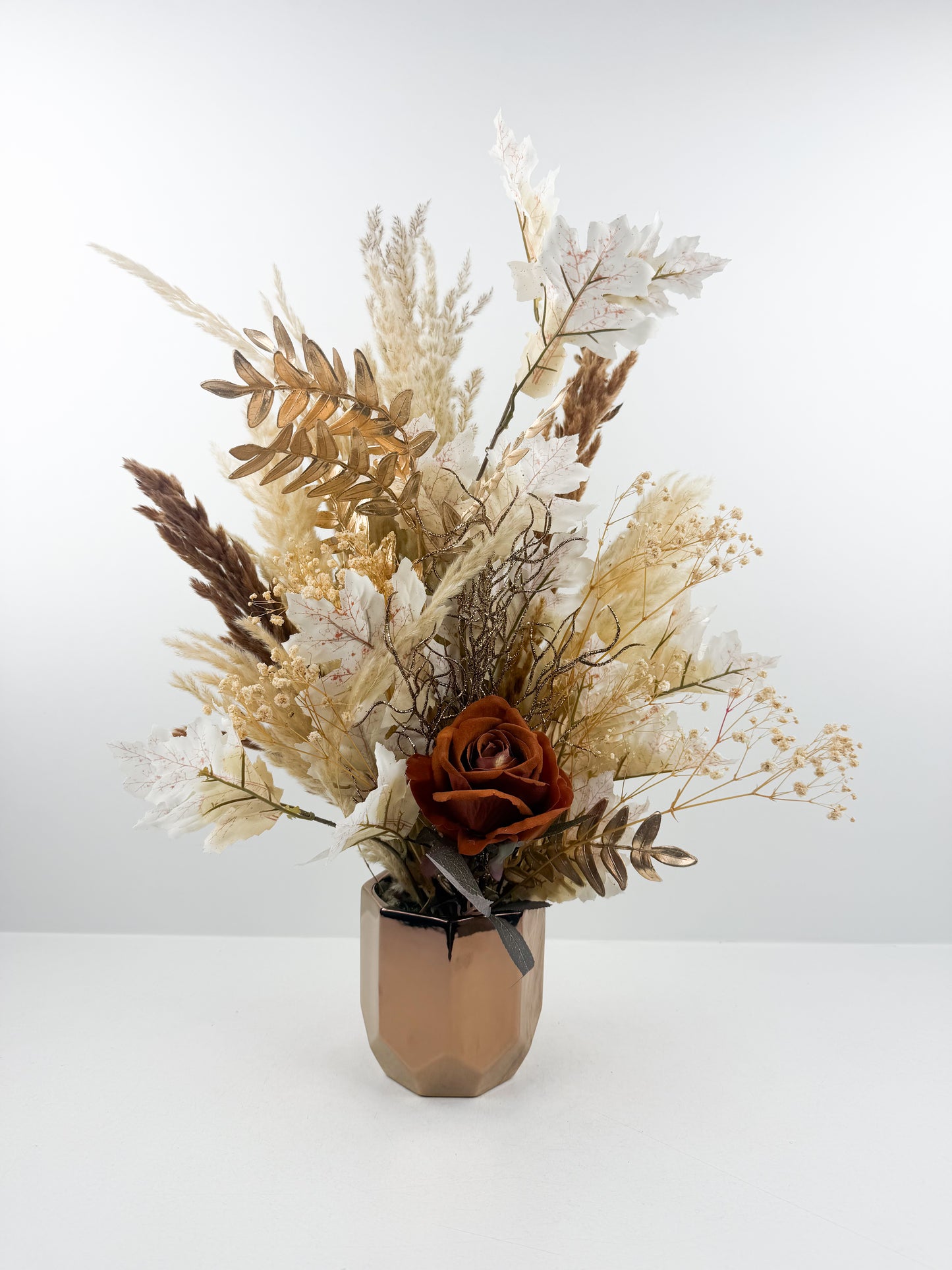 Fleurs séchées marron avec une fleure marron foncé luxe dans un pot en céramique bronze aux finitions miroir.