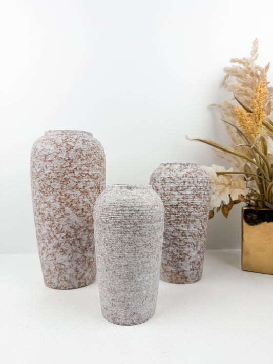 Trio de vases aux teintes marron et blanc en céramique alliant élégance et raffinement.