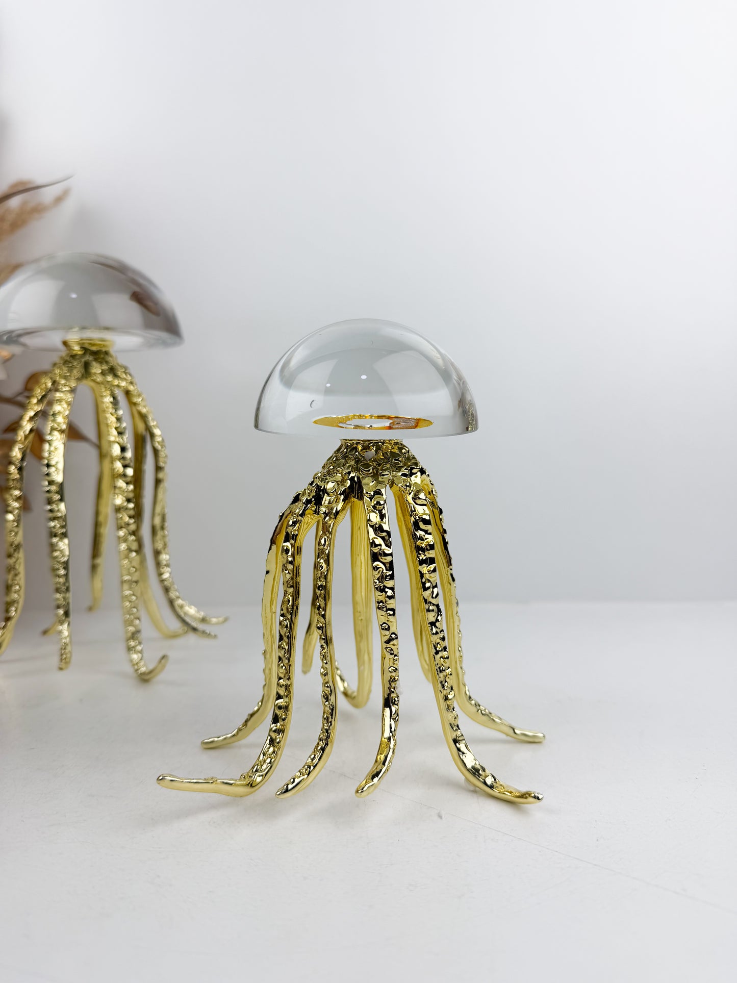 Trois sculptures de méduses dorées en métal avec un dôme en cristal