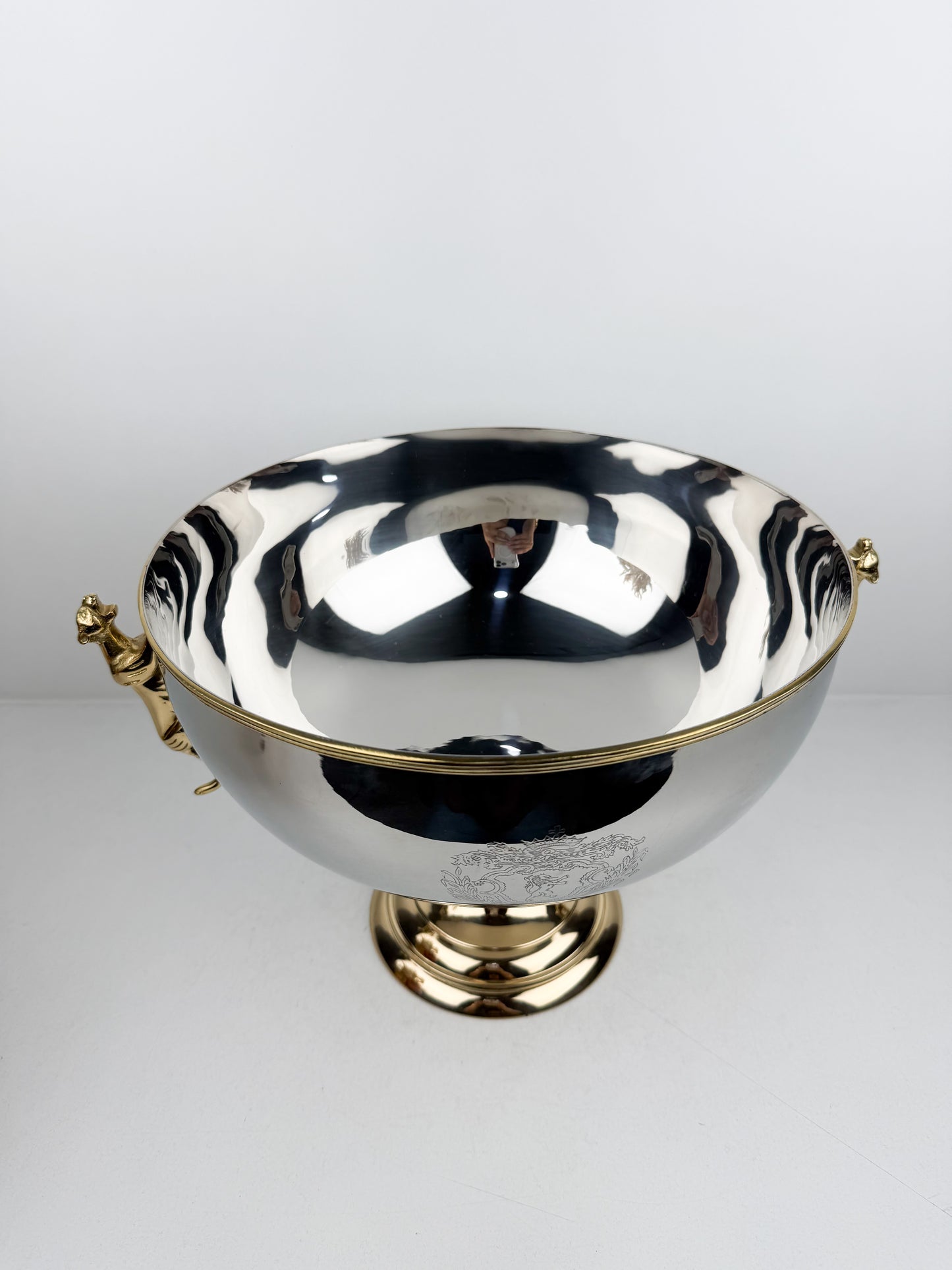 Présentoir très chic et luxe en métal miroir avec pieds dorés et poignées en forme de tigre.