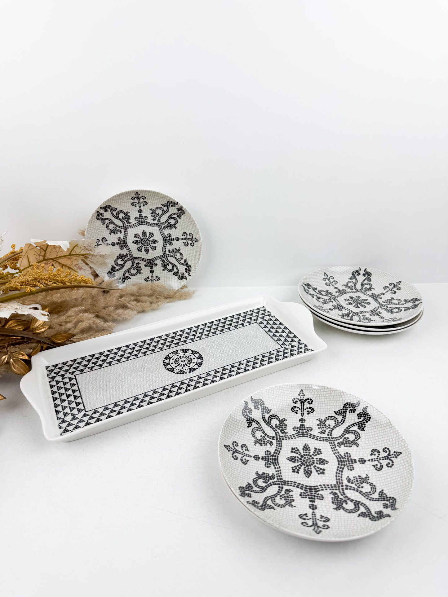 Ensemble de service élégant d'une grande assiette de présentation et de six assiettes assorties ornées en noir et blanc