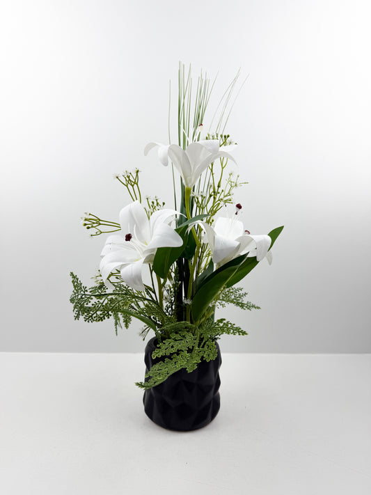 Fleurs artificielles blanches délicates dans un élégant pot noir en céramique de luxe.