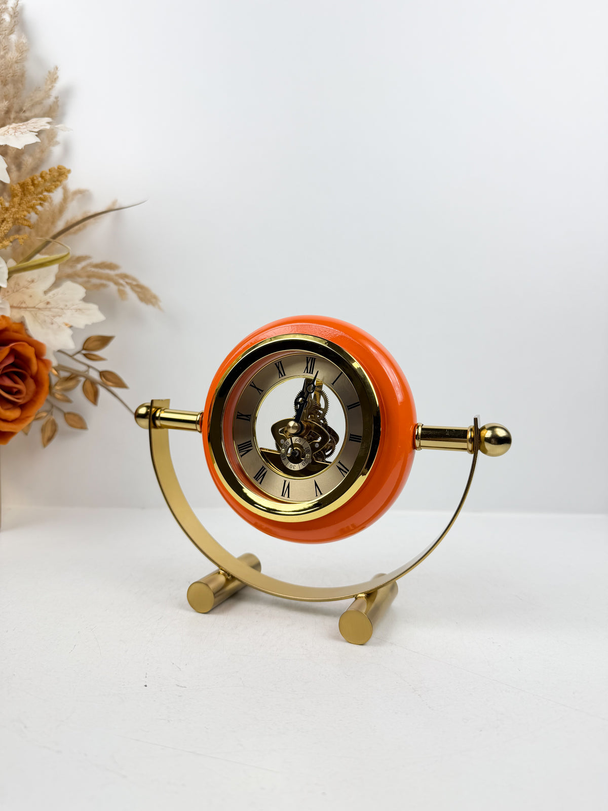 Horloge de table en métal doré de contour orange.