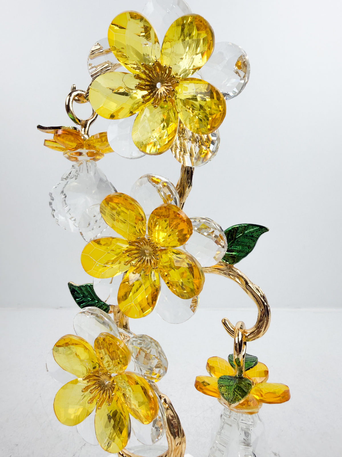 Sculpture d'arbre décoratif avec fleurs et cristaux dorés.