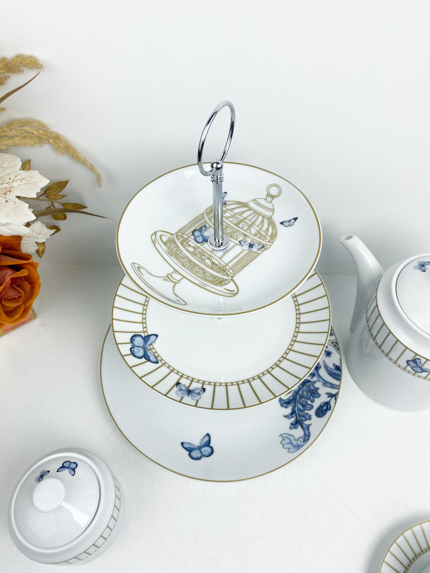Service à thé en porcelaine décoré de motifs de papillons et d'une cage à oiseaux
