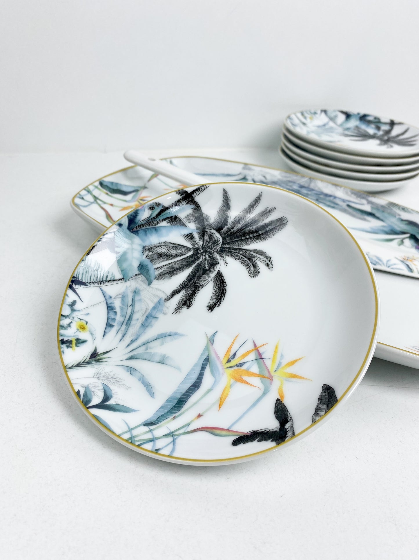 Set de 8 pièces a gâteaux en porcelaine avec motif floral de jungle et une bordure dorée.