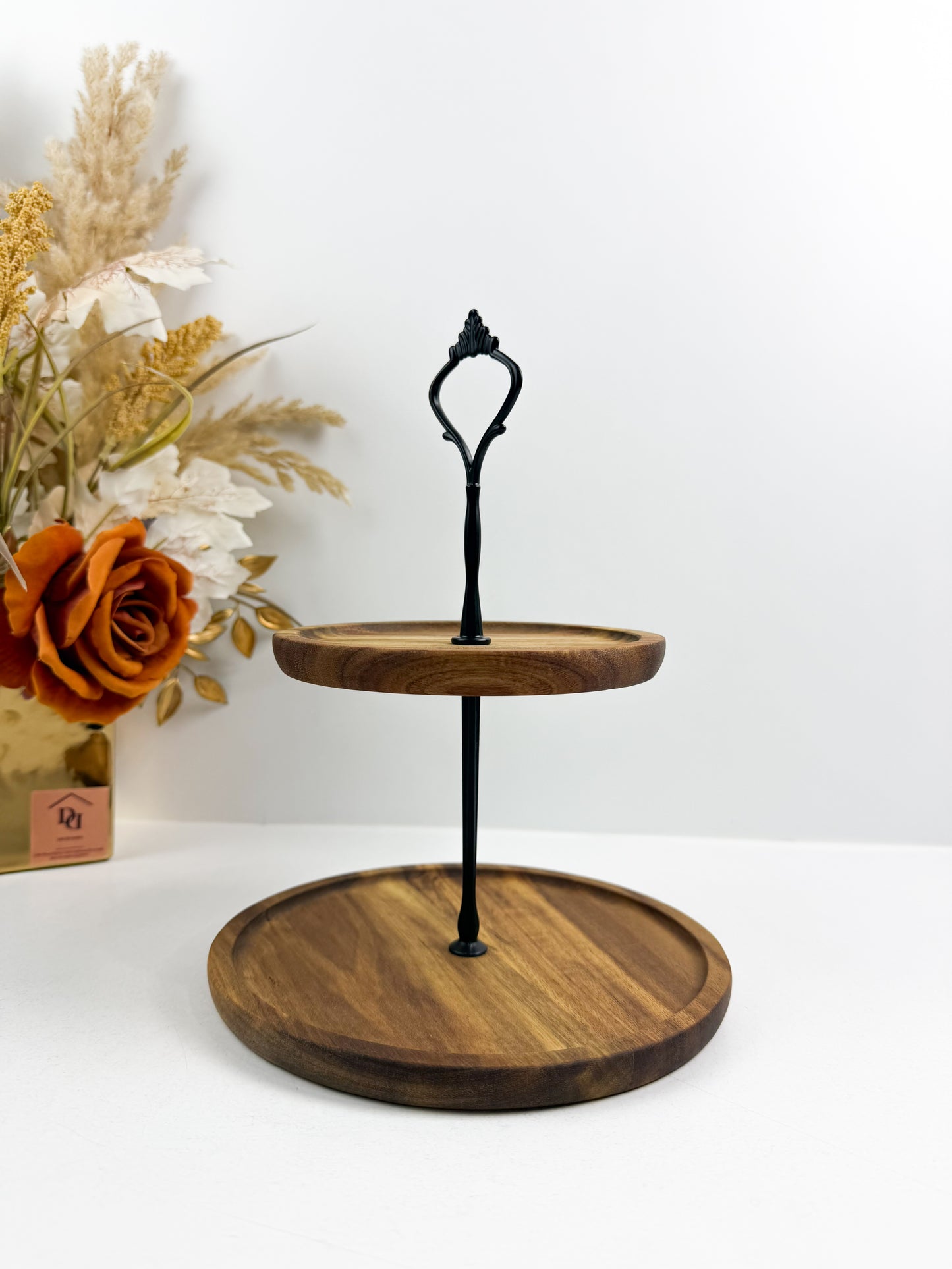 Présentoir à gâteaux à 2 étages en bois  avec une poignée noire.