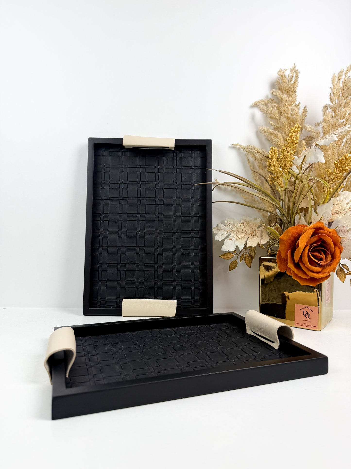 Ensemble de plateaux de service noirs avec une texture tressée et des poignées beiges.