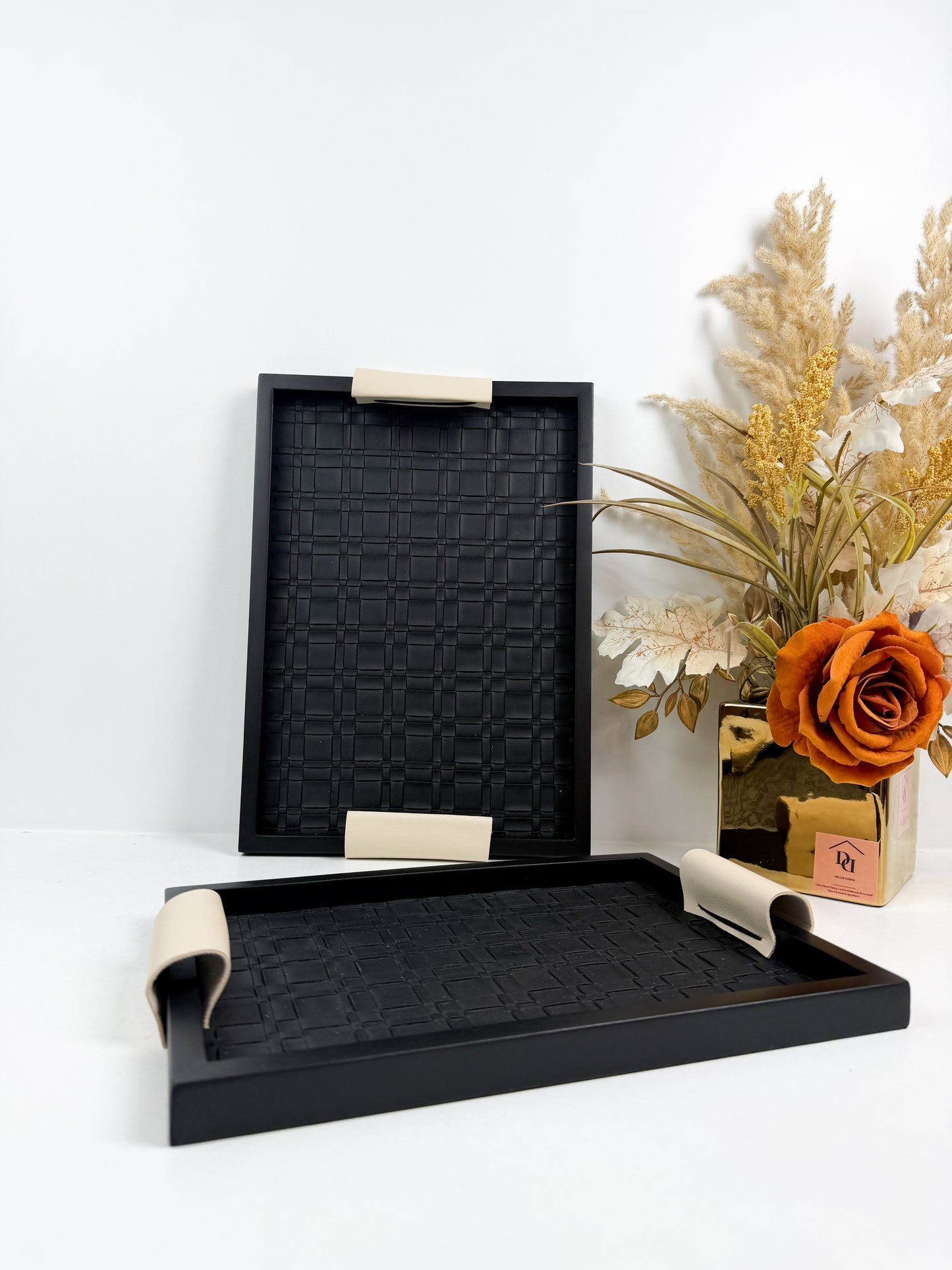 Ensemble de plateaux de service noirs avec une texture tressée et des poignées beiges.