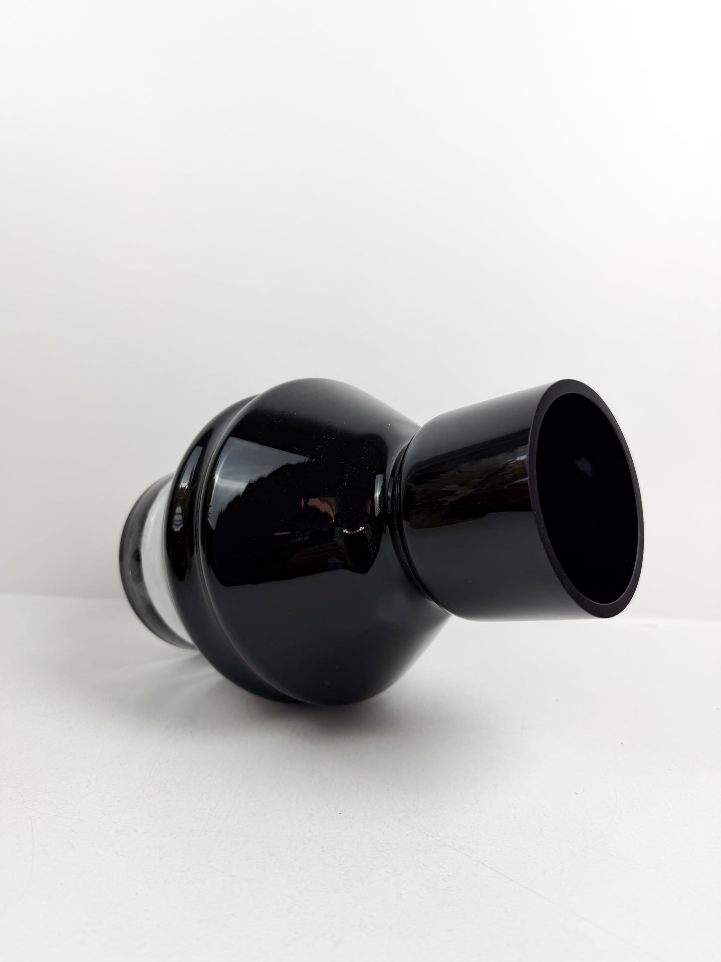 Vase design en verre noir brillant avec une base transparente