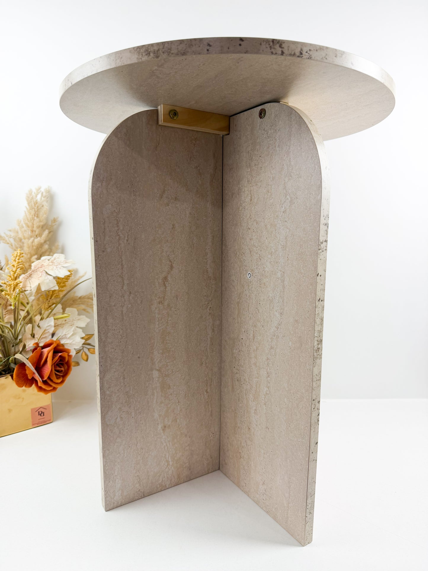 Table d'appoint de style moderne avec une base arquée et des fixations en laiton.