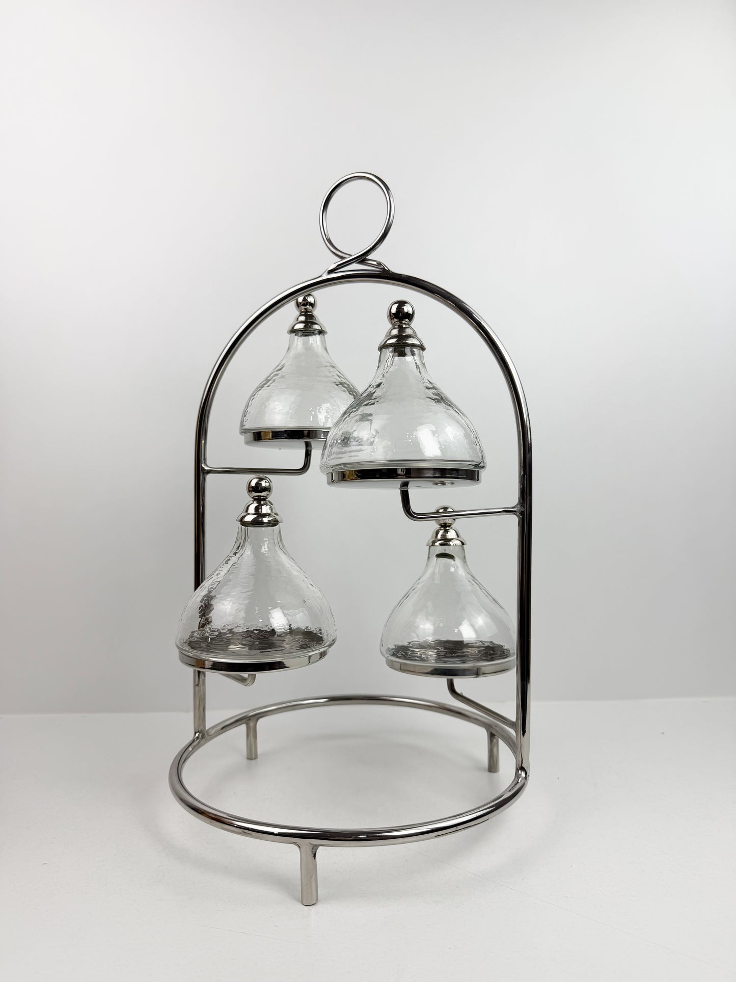 Présentoir à gâteaux ou à desserts à plusieurs niveaux en métal chromé, avec quatre cloches individuelles.