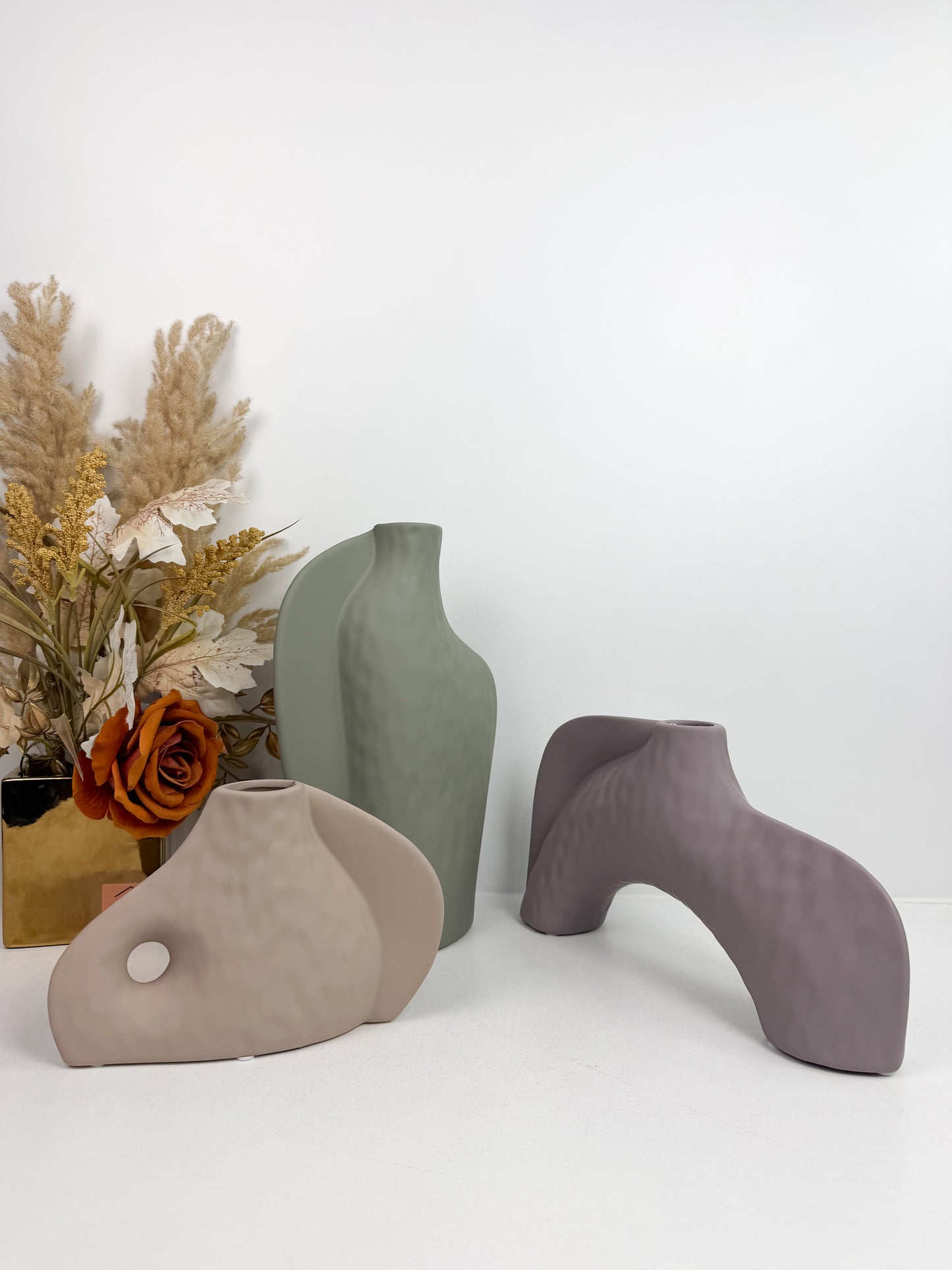 Trois vases décoratifs en céramique aux formes abstraites et aux couleurs neutres