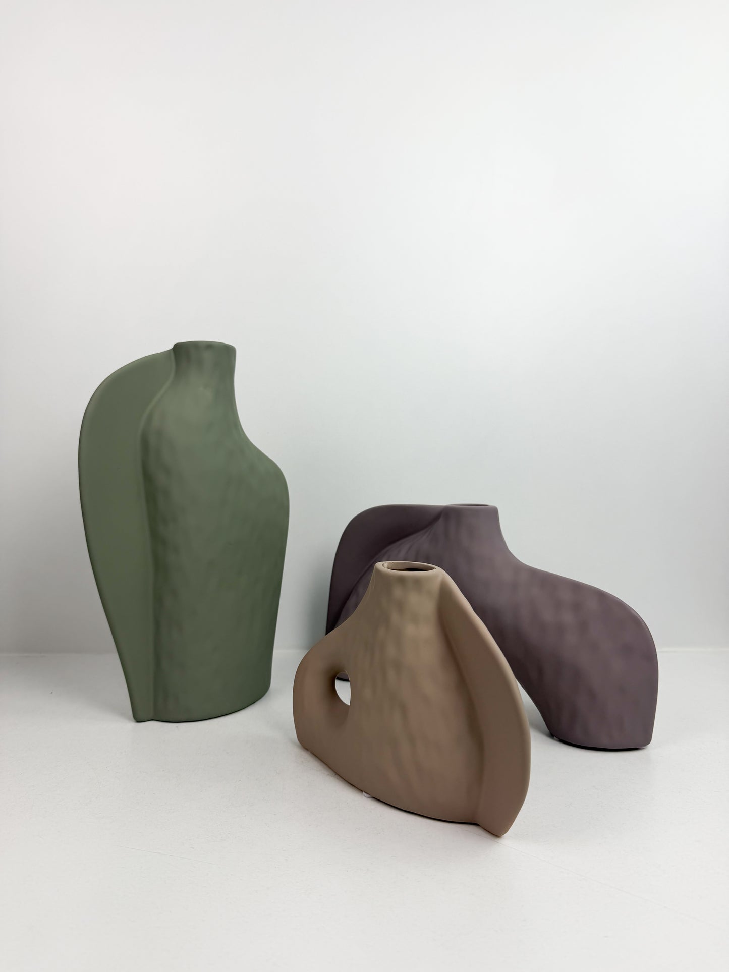 Trois vases décoratifs en céramique aux formes abstraites et aux couleurs neutres